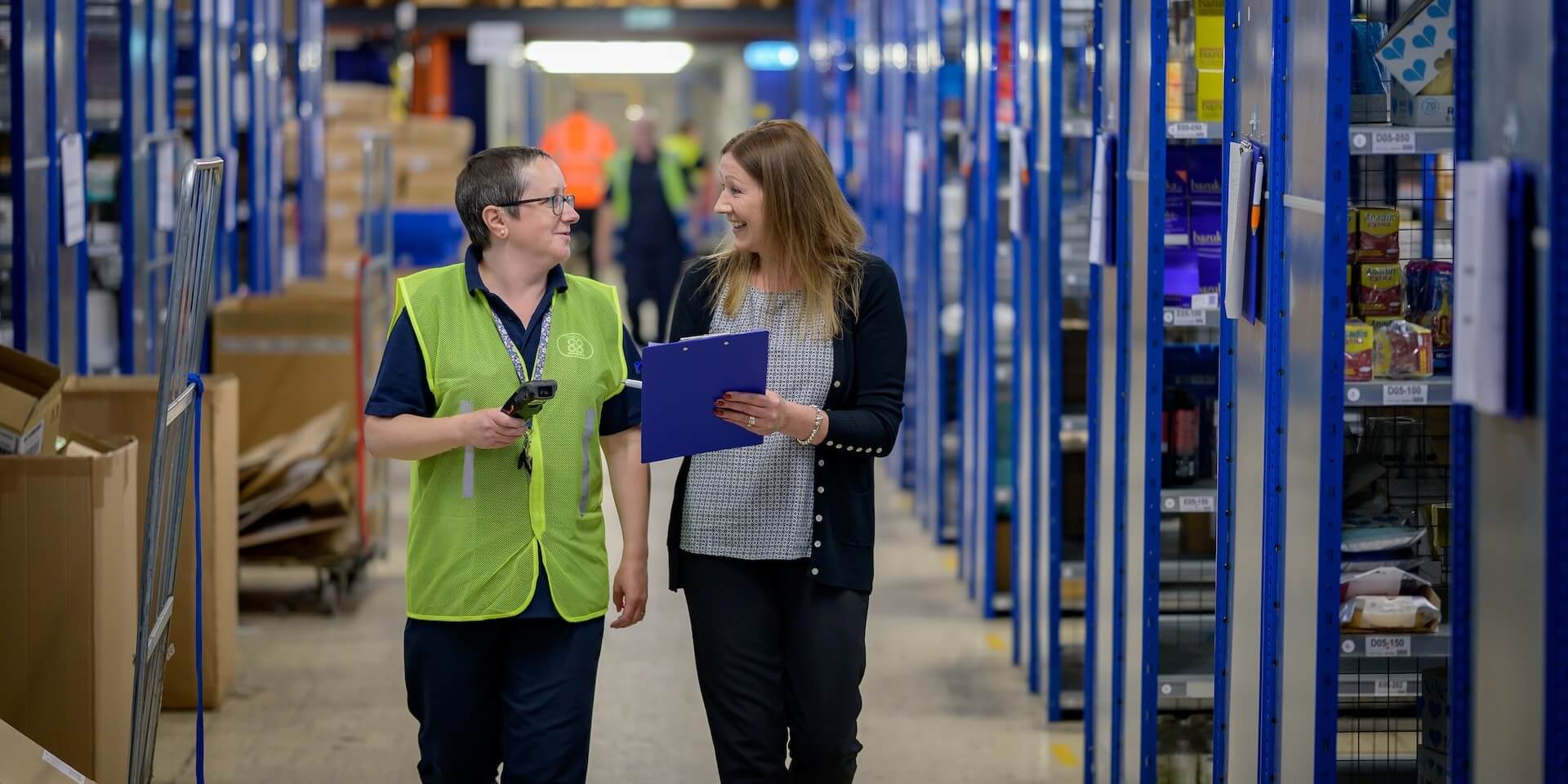 safety planning two women walk down a long hallway with clipboard